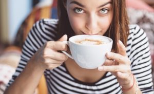 Young woman drinking coffee in urban cafe